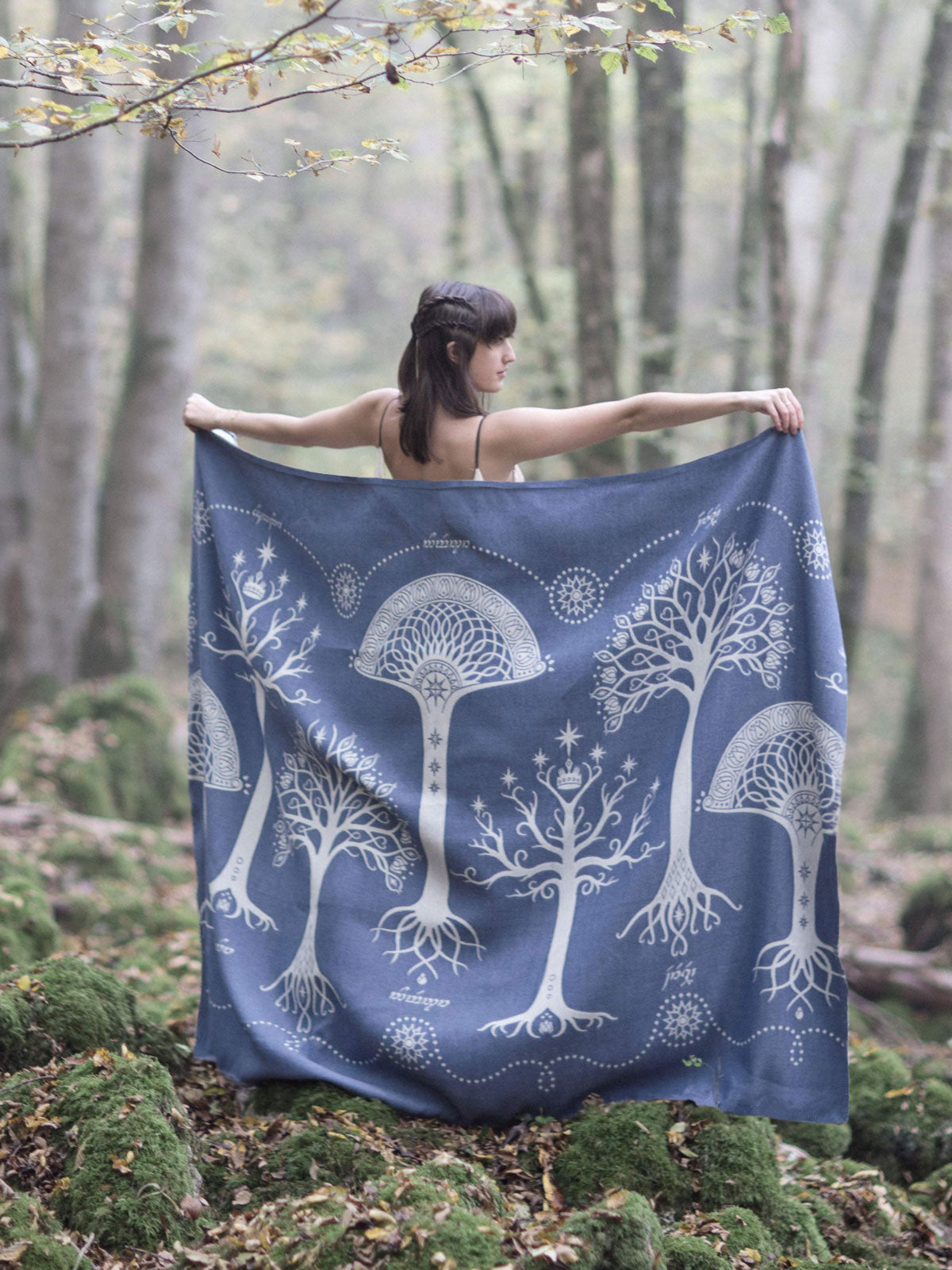Oscha Ancients of Gondor Hith blue throw being held up in the woods