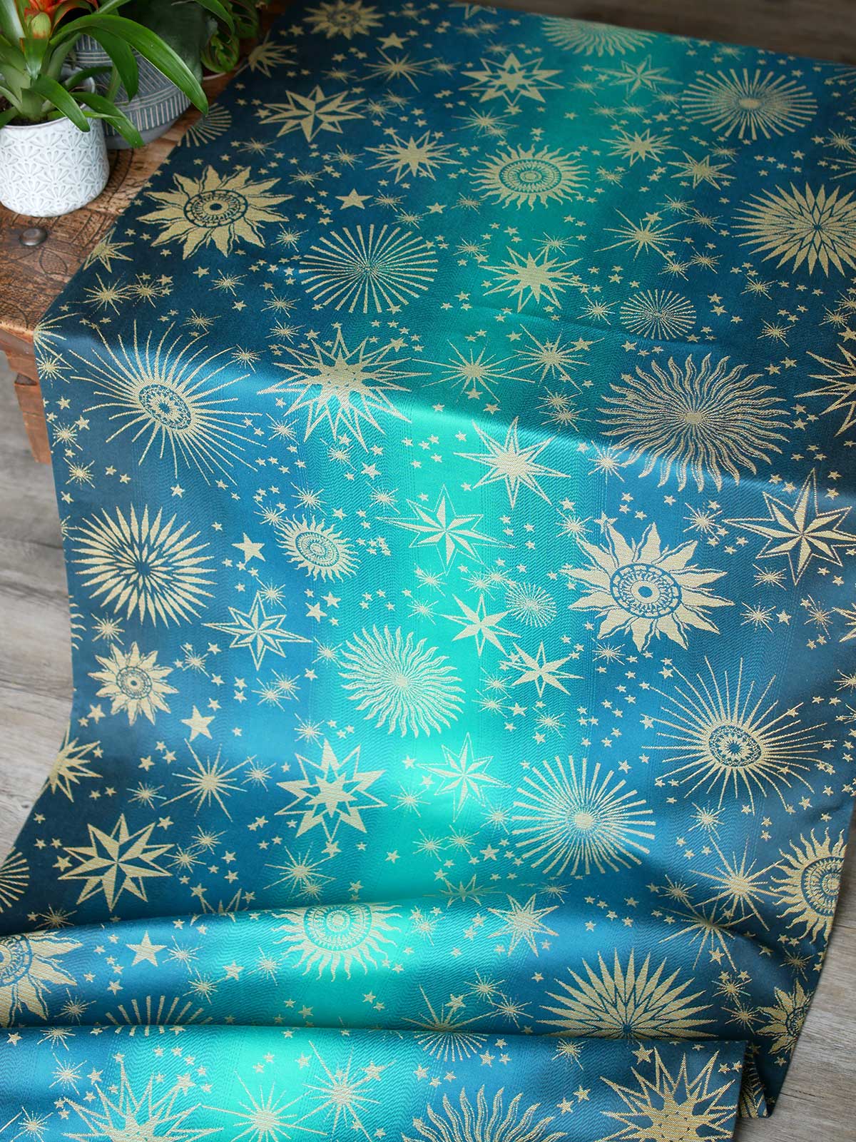 Teal fabric with starry pattern on a wooden surface