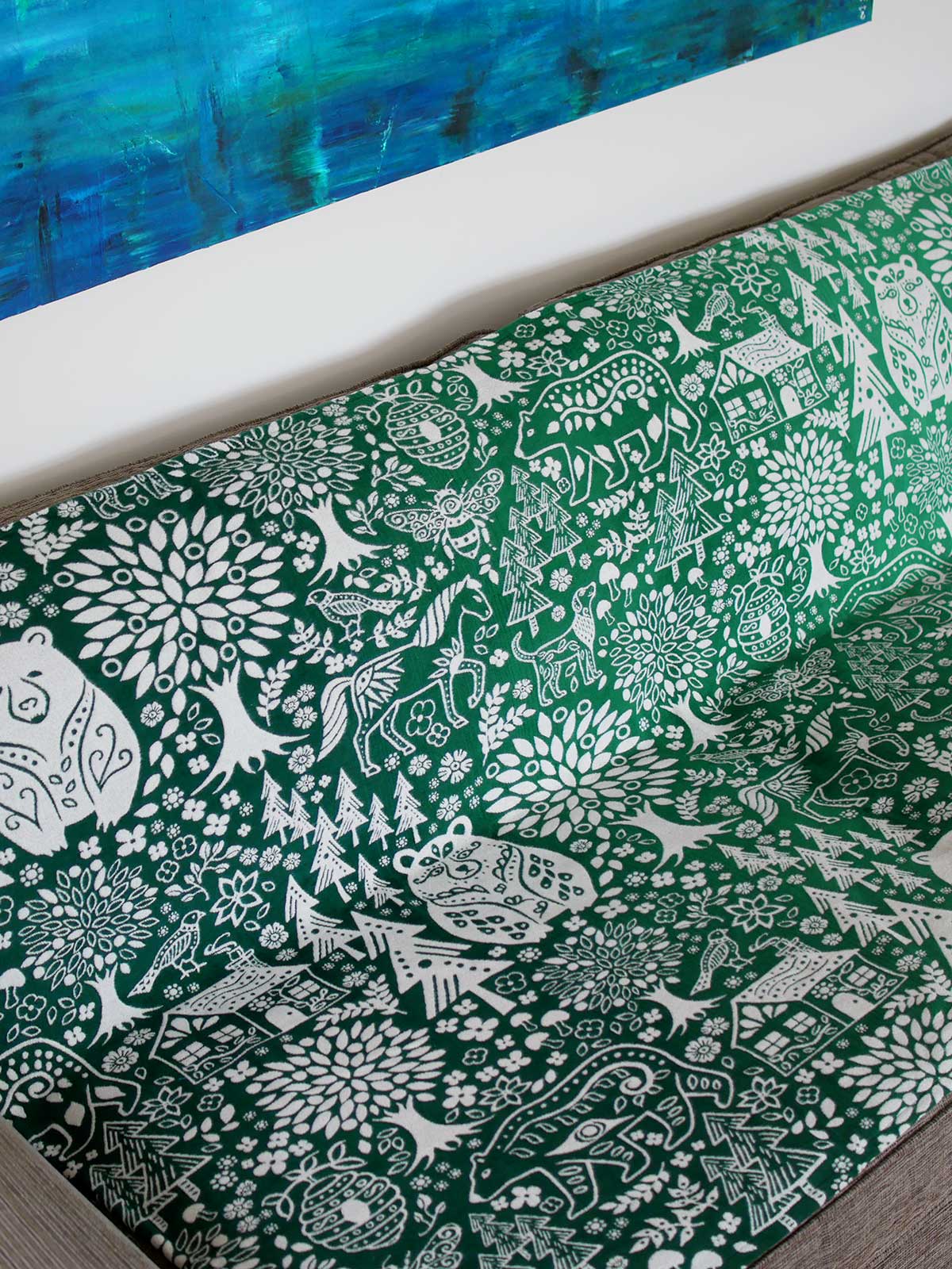 Green throw with folk art design .