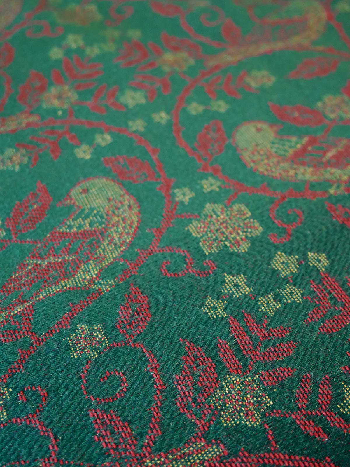 Close-up of a green fabric with red floral and leaf pattern