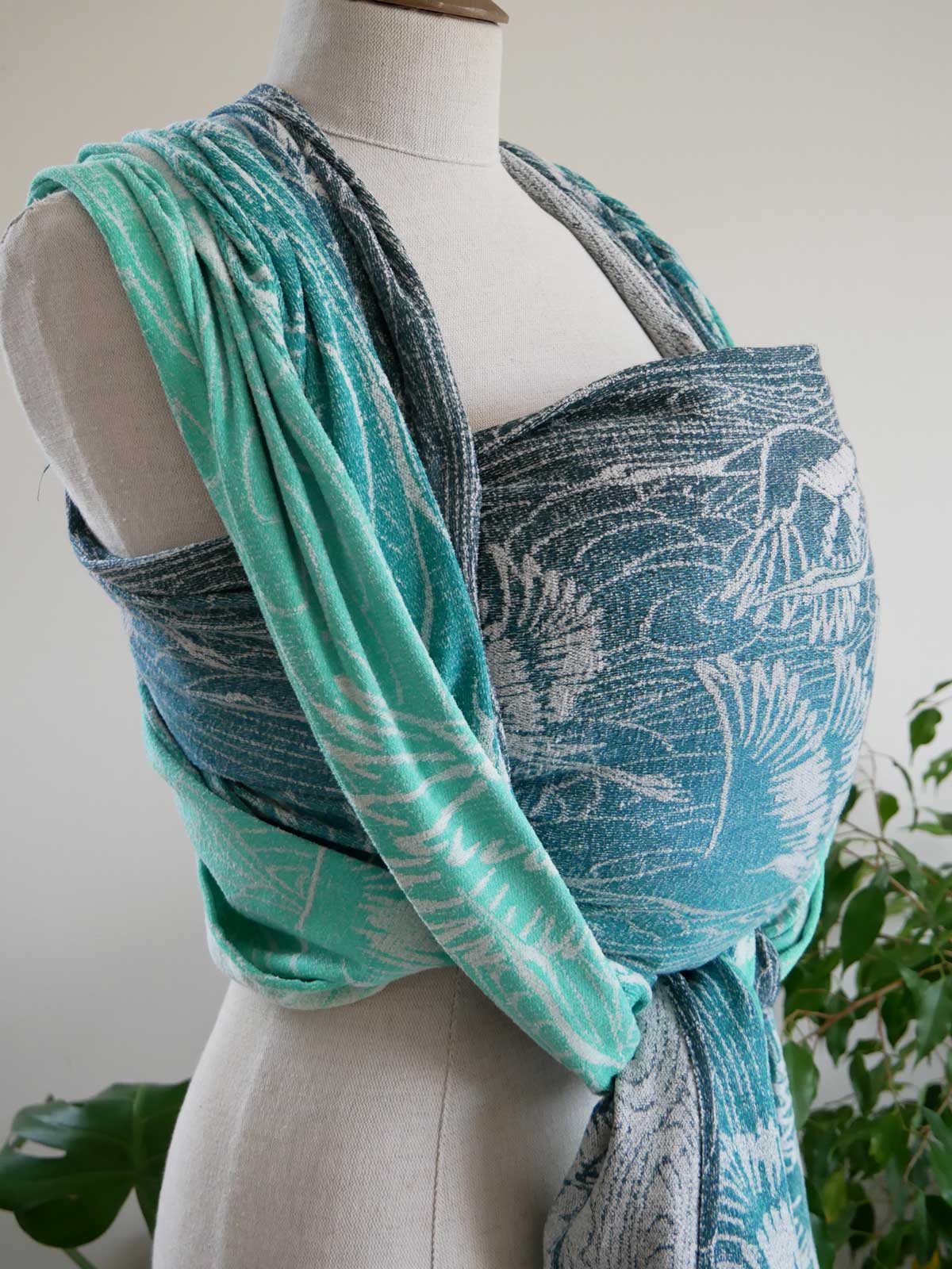 Mannequin wearing a blue and green patterned wrap with a white background