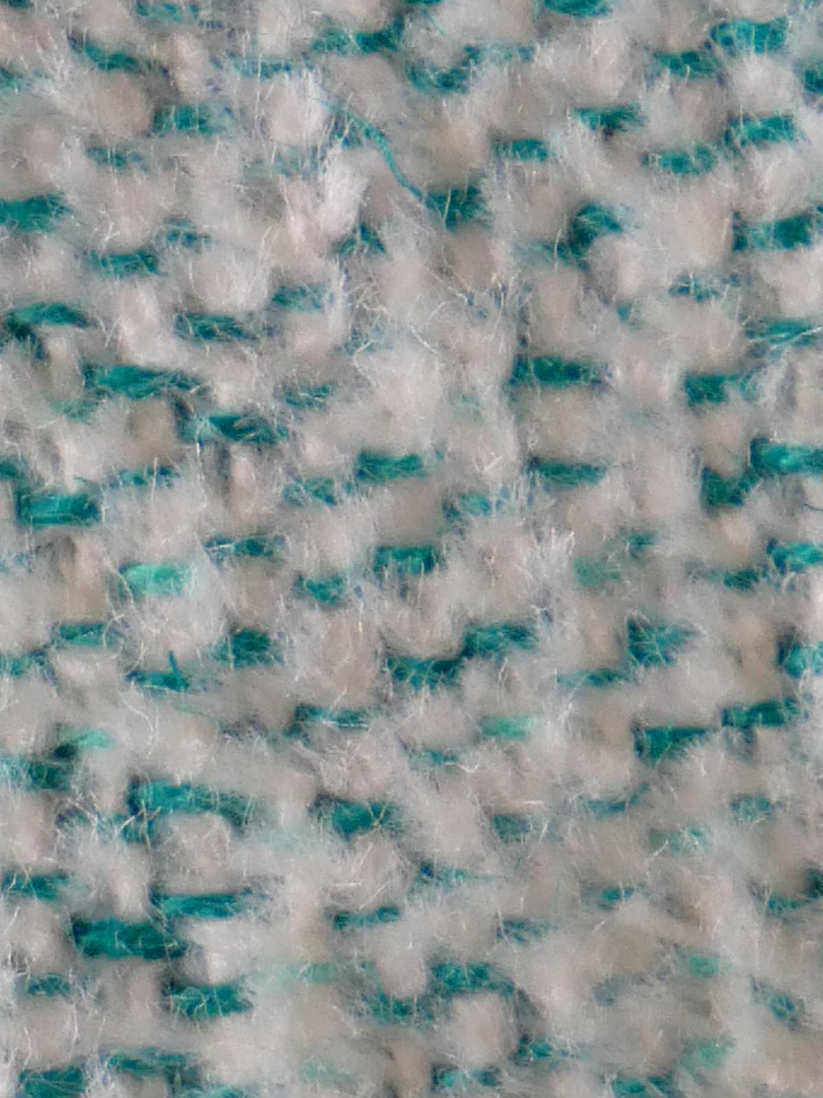 Close-up of a textured fabric with white and teal pattern