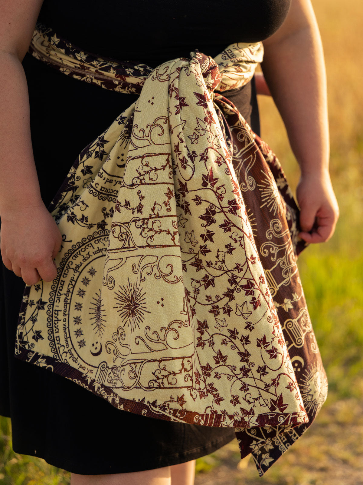 Person wearing a woven wrap in a natural setting