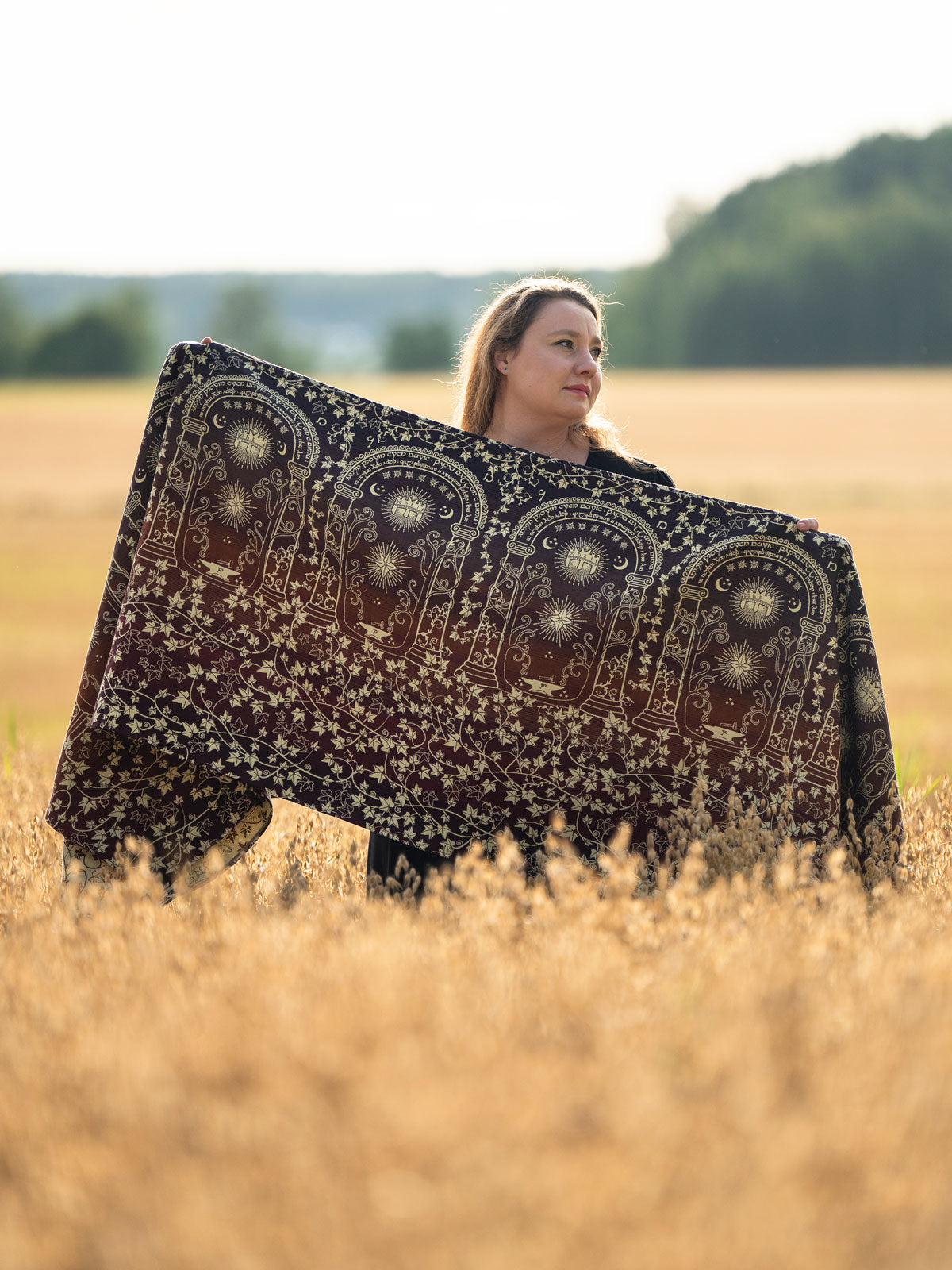 Woman holding a woven wrap in a field