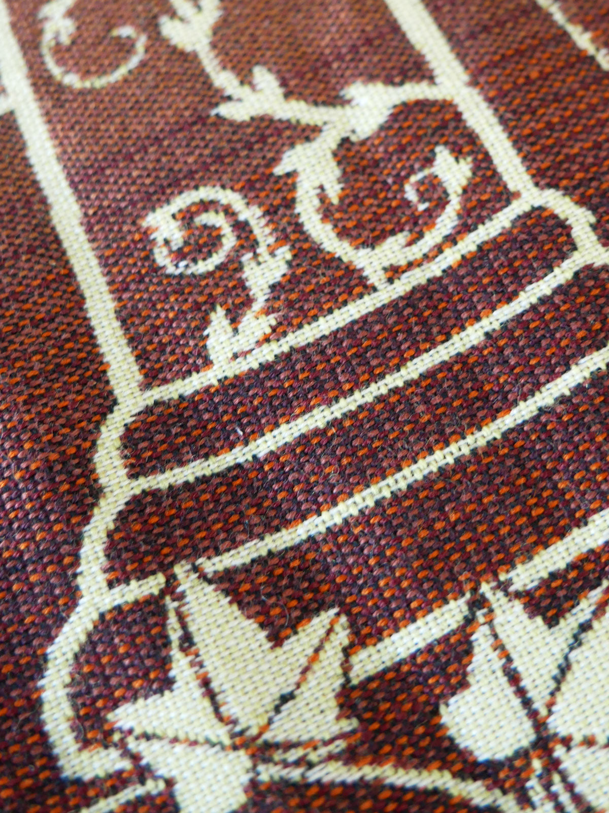 Close-up of a woven fabric with intricate patterns and text.