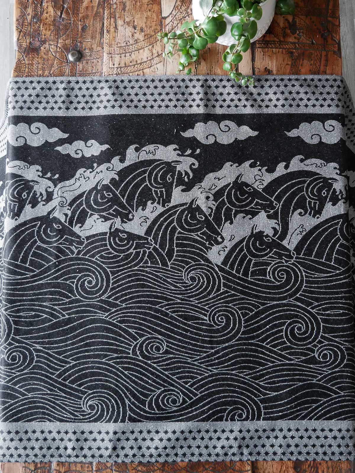 Textile with horse and wave pattern on a wooden surface