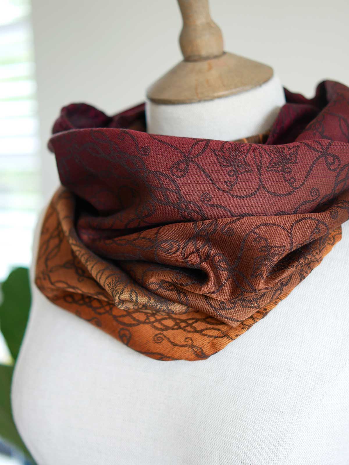 Red and carmel coloured cowl on a mannequin.