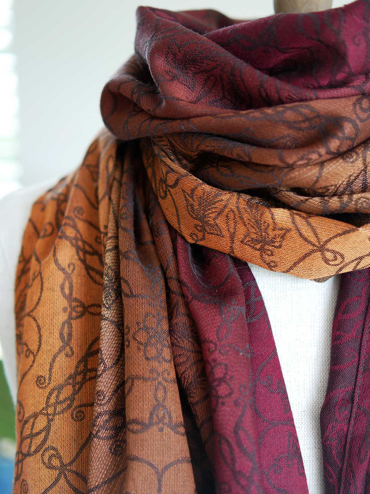 Close up of red and carmel colouted scarf on a mannequin.