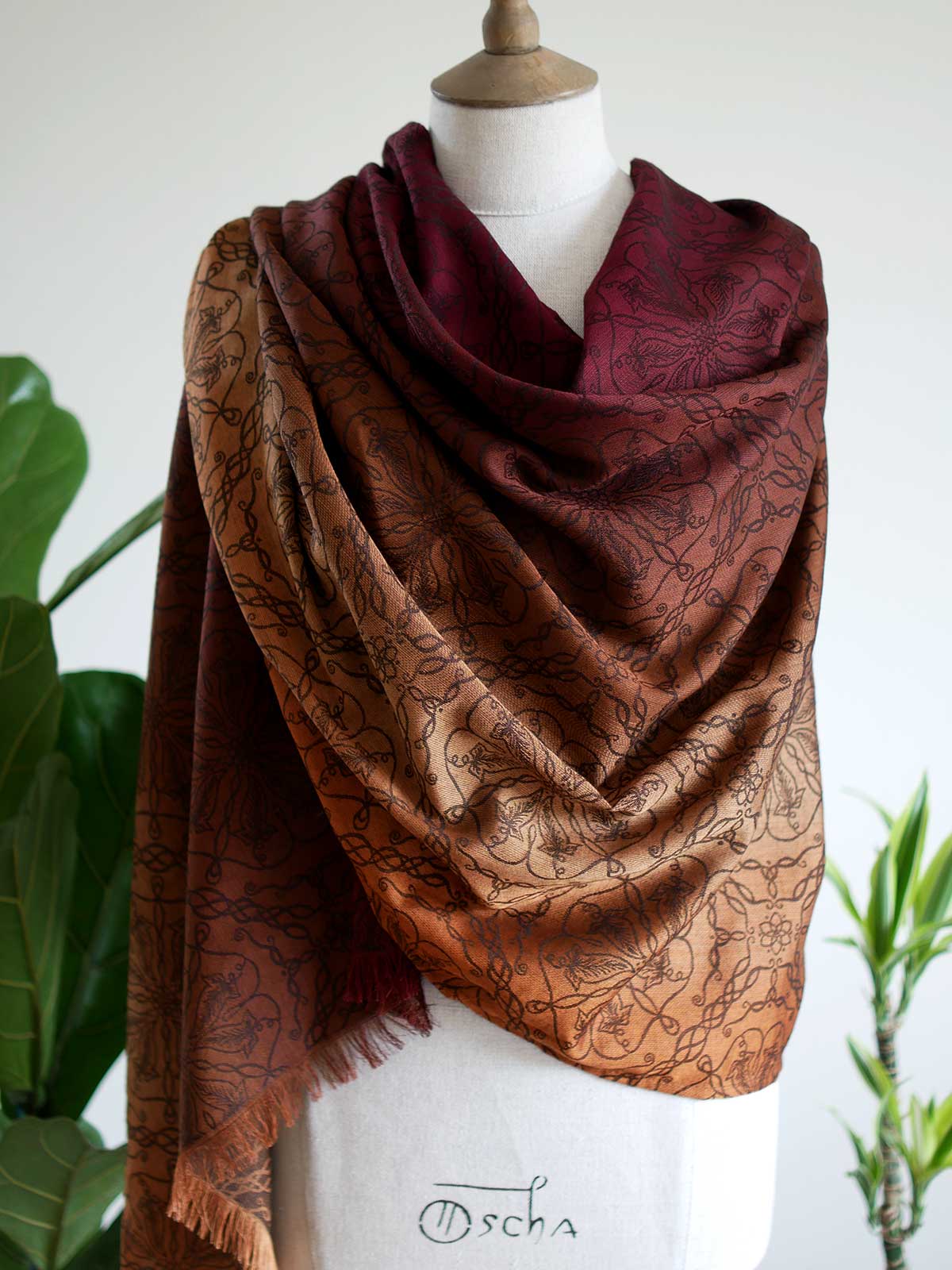 Red and carmel colouted scarf draped on a mannequin.