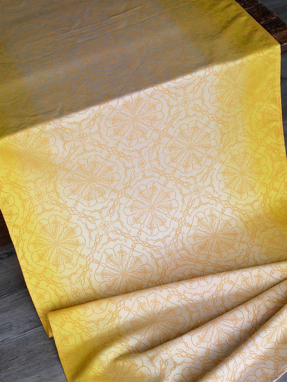 Lemon yellow graduated fabric woven with Ice Cotton draped on a table.