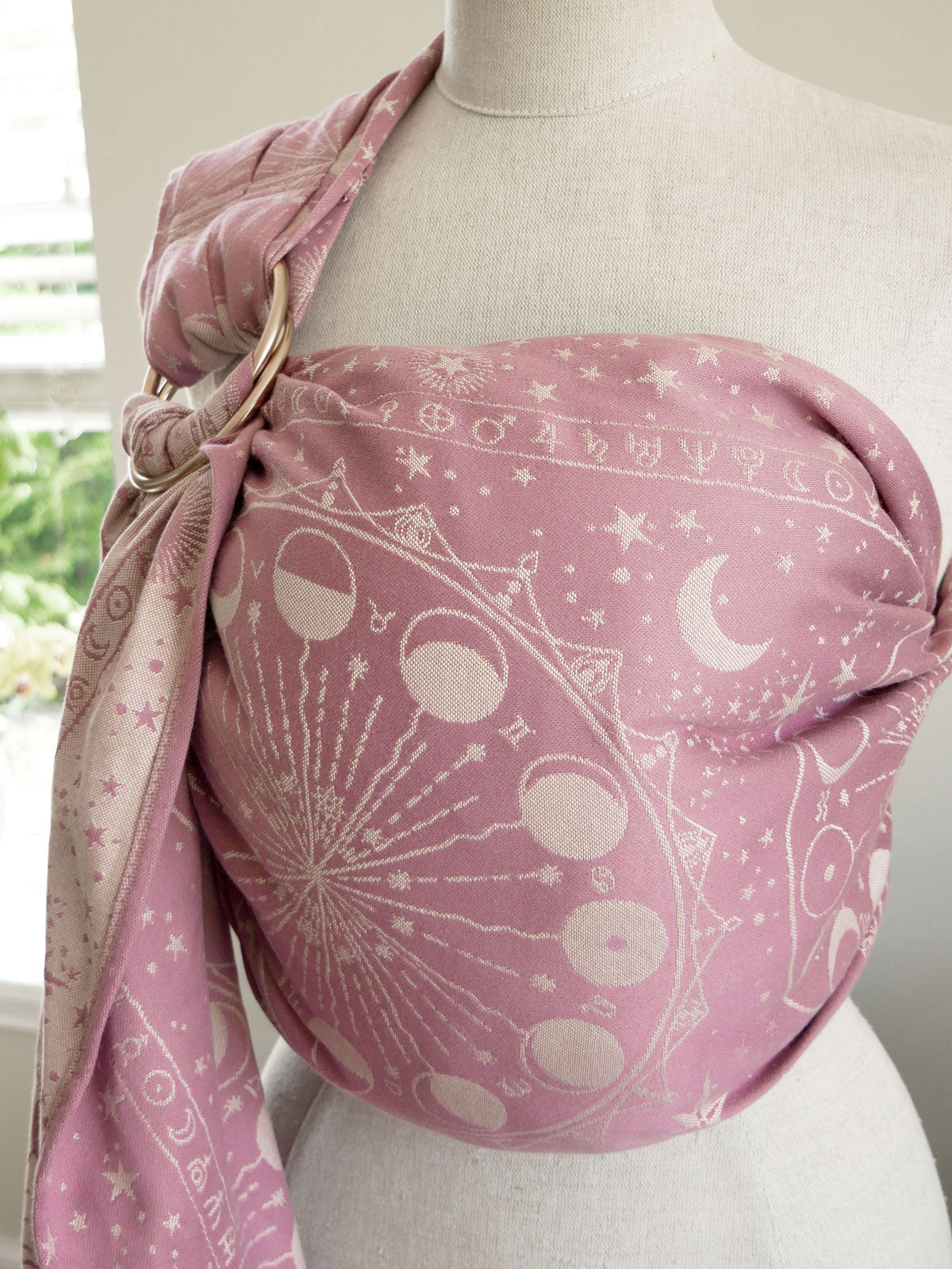 Pink baby ring sling with celestial pattern on a mannequin