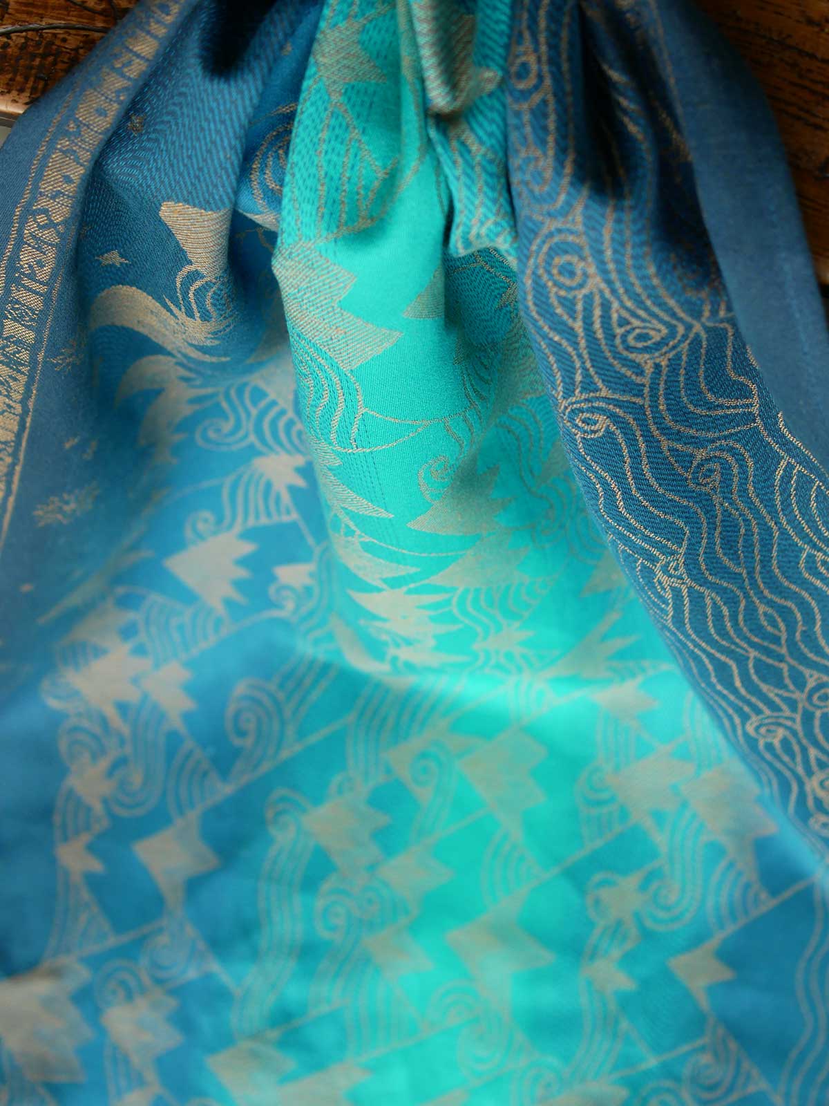 A blue teal fabric with a gold mountain pattern