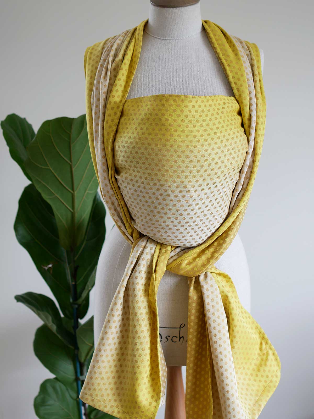 Front view of a lemon and gold woven wrap with dots on a mannequin.