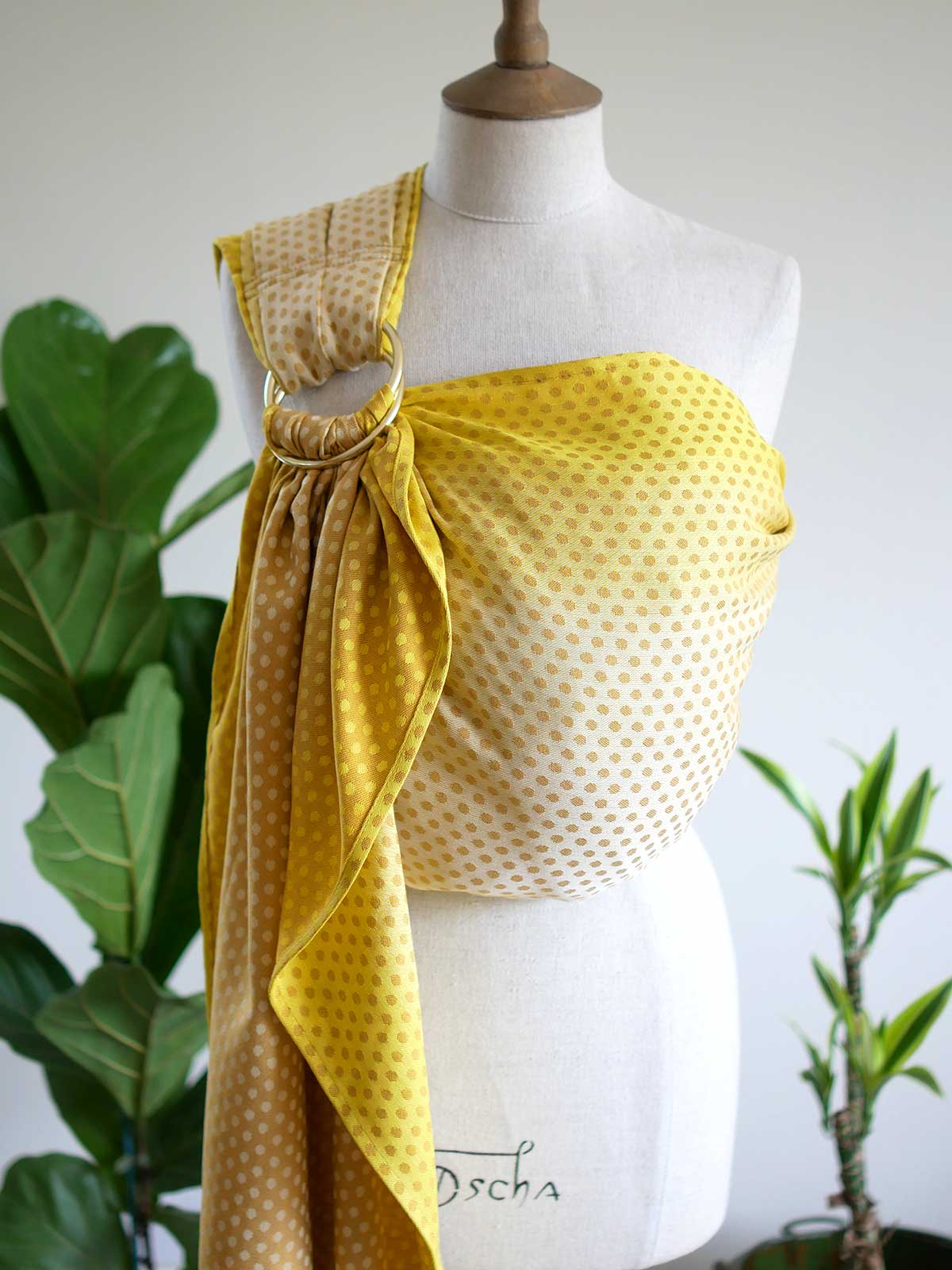 Front view of a lemon and gold ring sling with dots on a mannequin.