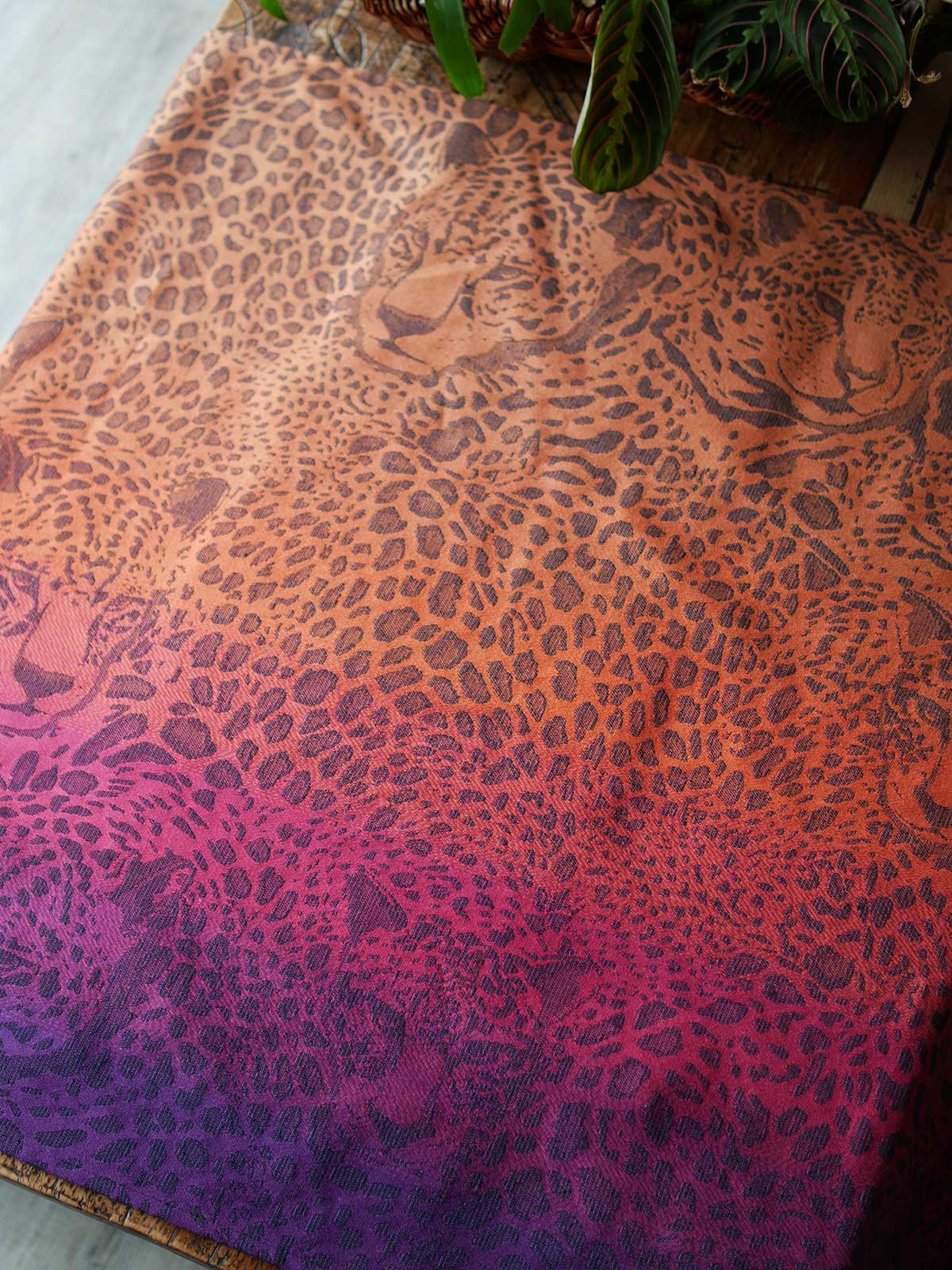 Leopard-print fabric in orange, pink and purple with leopard faces.