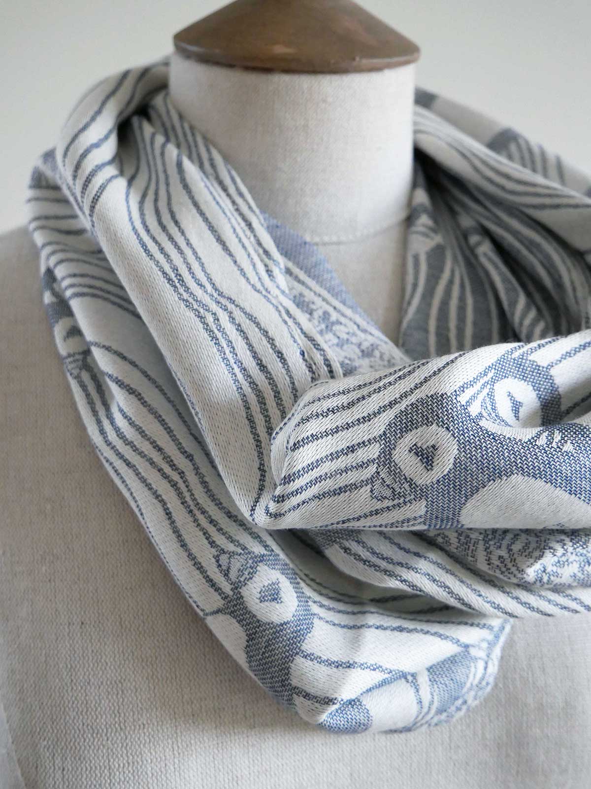 Blue and white patterned scarf on a mannequin with a neutral background