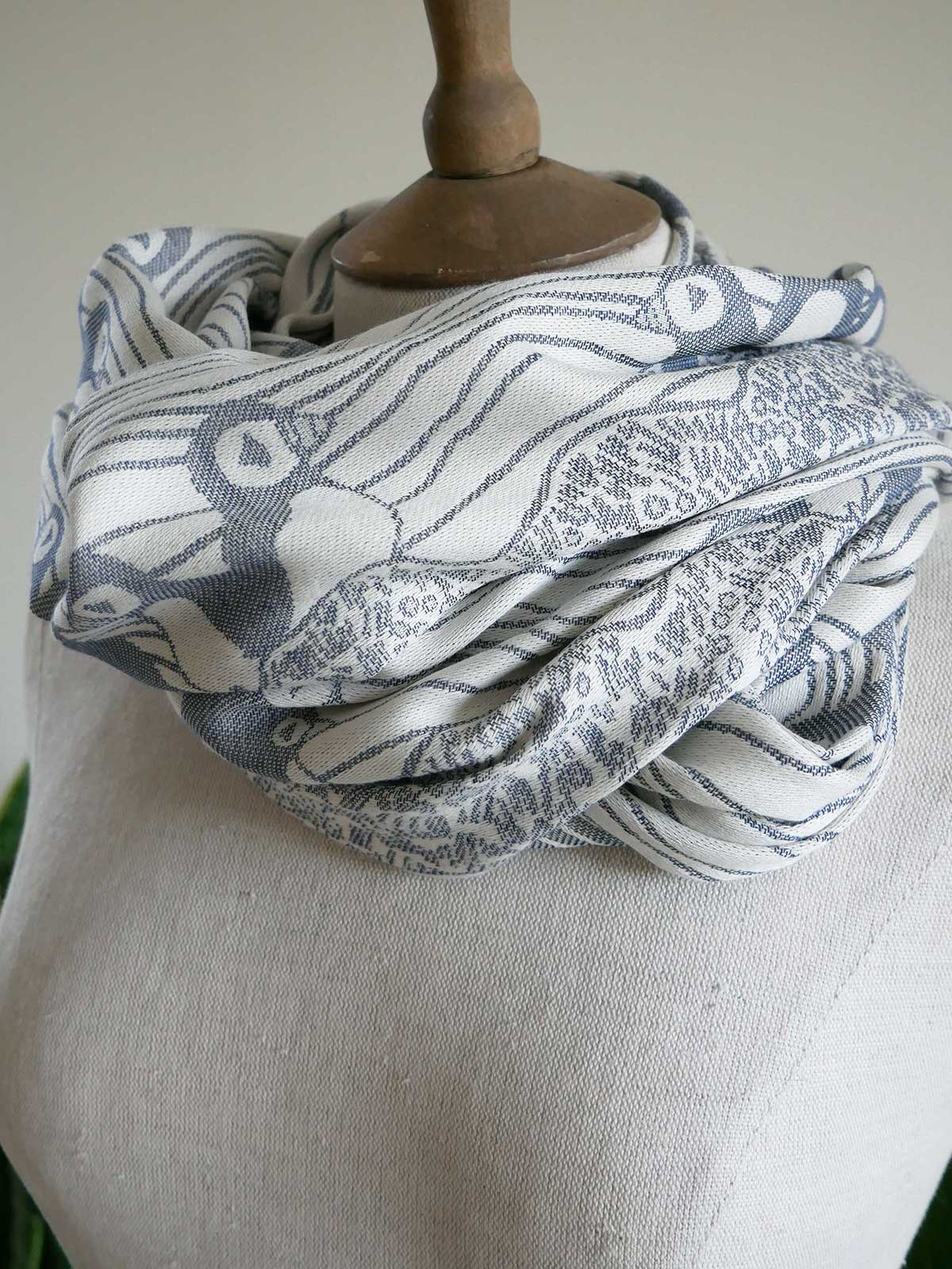 Scarf with blue and white pattern draped over a mannequin bust.