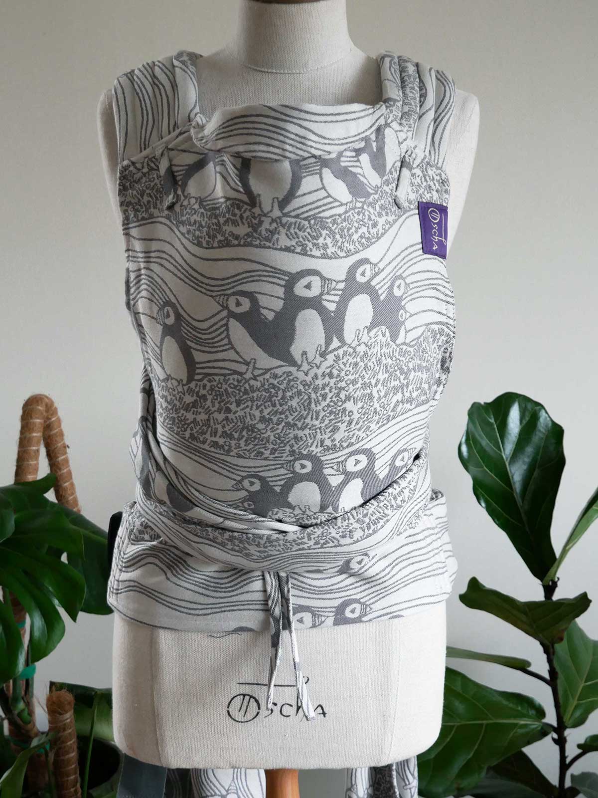 Baby carrier with puffin design on a mannequin against a neutral background