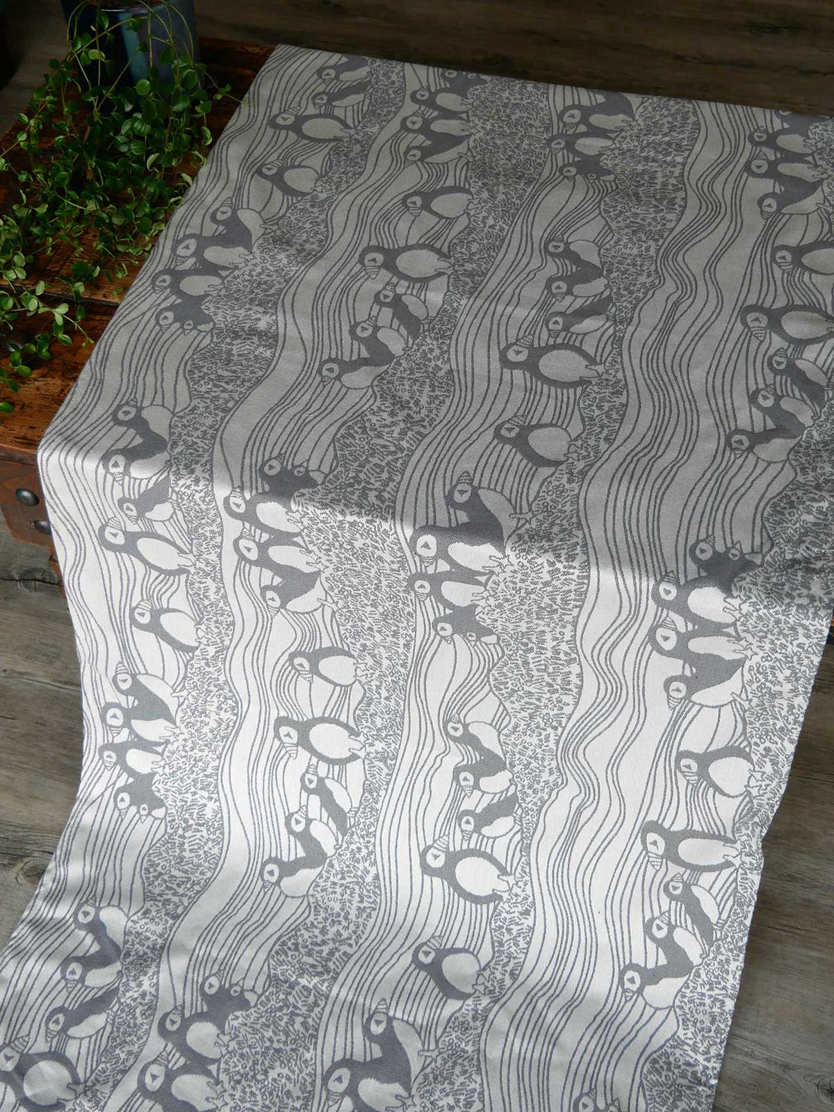 Fabric with a black and white pattern of birds and wavy lines on a gray background.