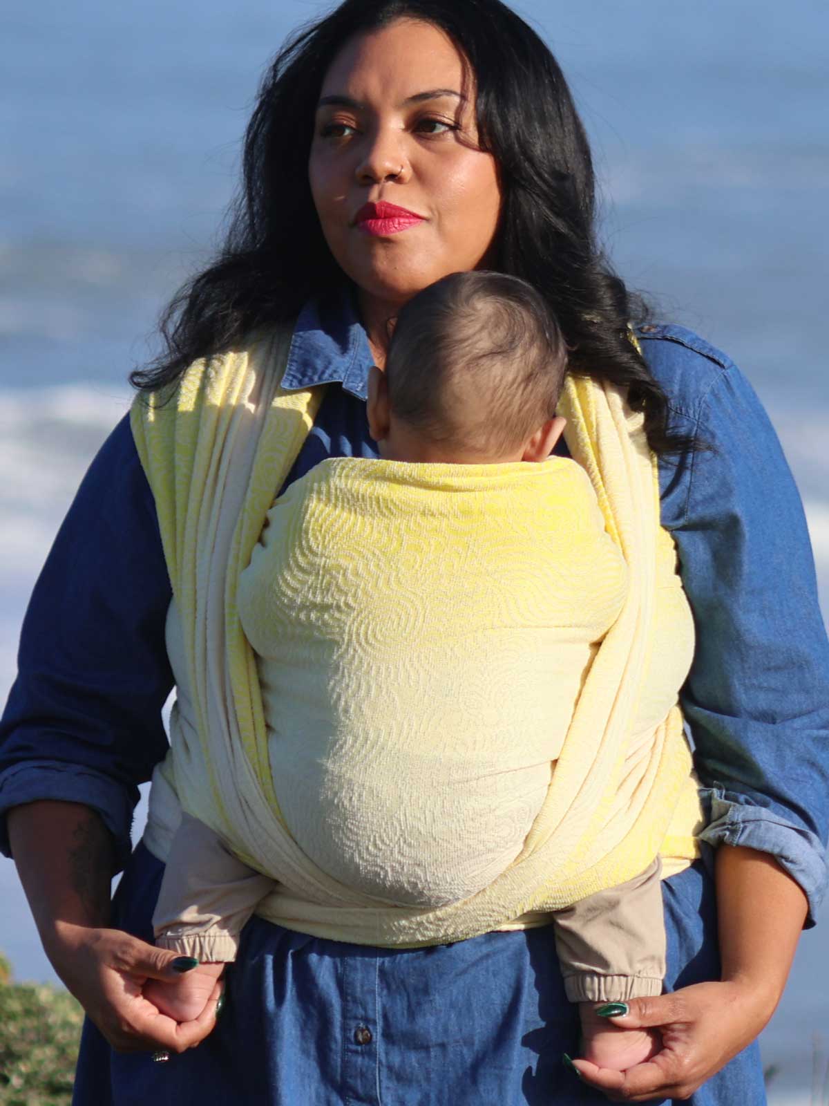 Woman with a baby in a yellow woven wrap.
