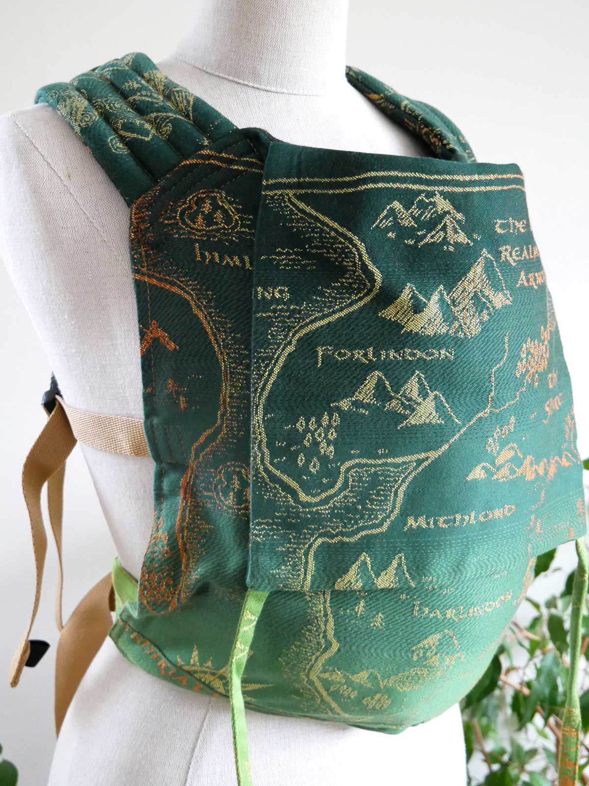 Green baby carrier with a map design on a mannequin