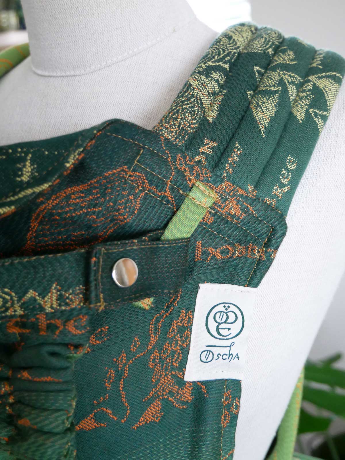 Close up of a strap of a green baby carrier