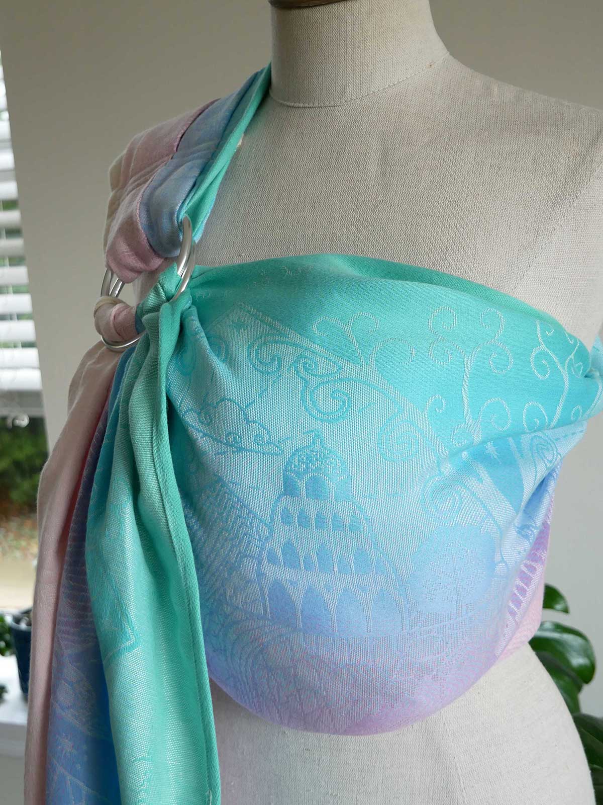 Mannequin wearing a turquoise ring sling with intricate patterns