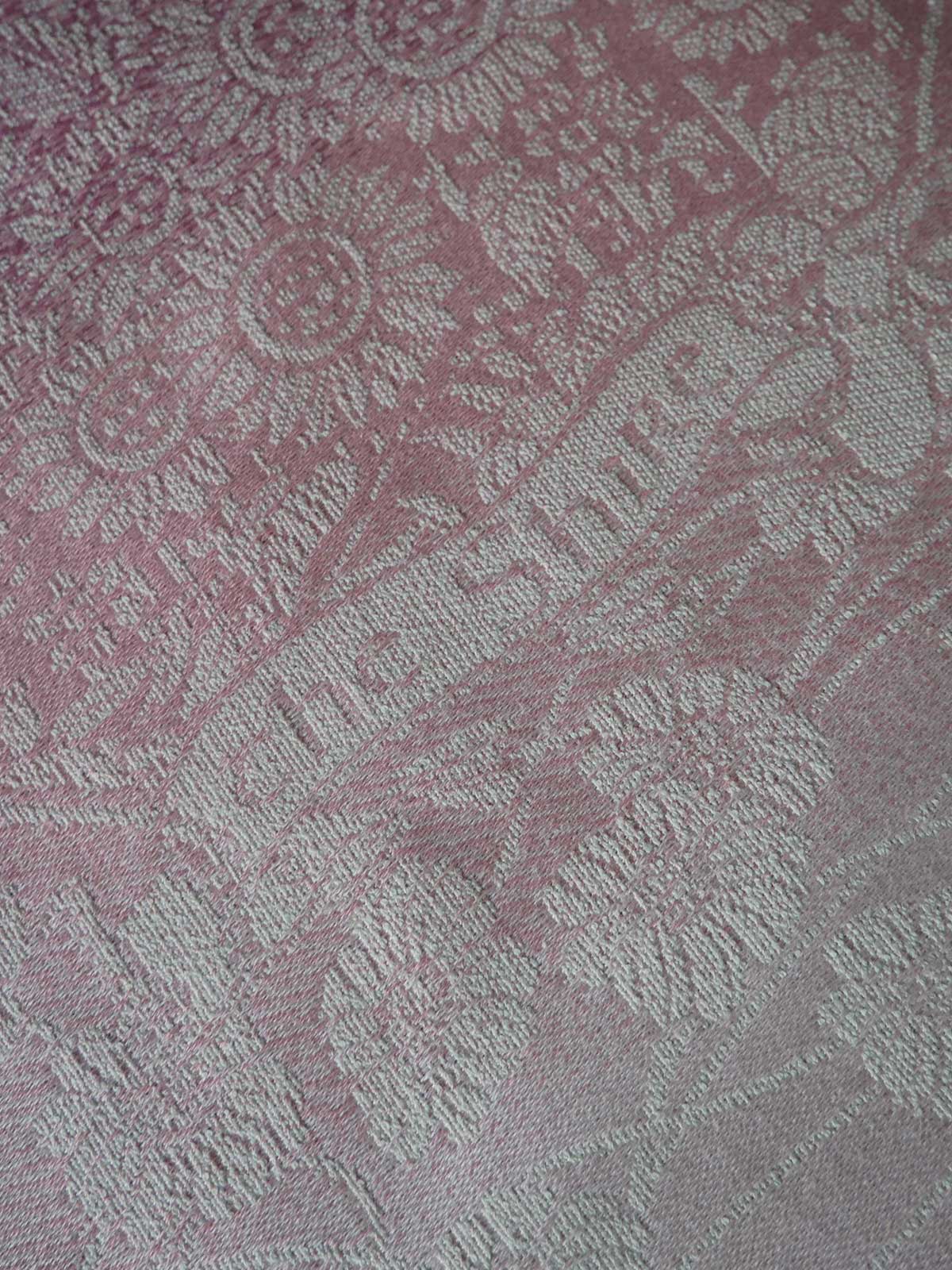 Close-up of textured fabric with a pattern in shades of pink and gray.