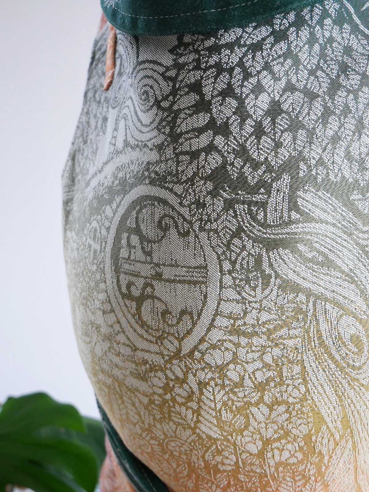 Close-up of a patterned fabric with intricate designs on a plain background