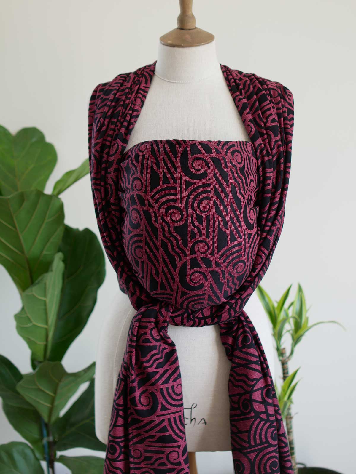 Front view of a black wrap with pink art deco pattern on a mannequin