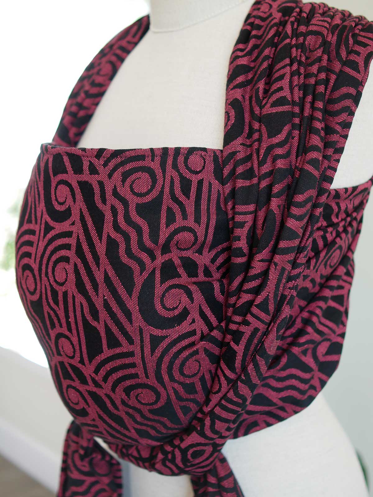 Side view of a black wrap with pink art deco pattern on a mannequin