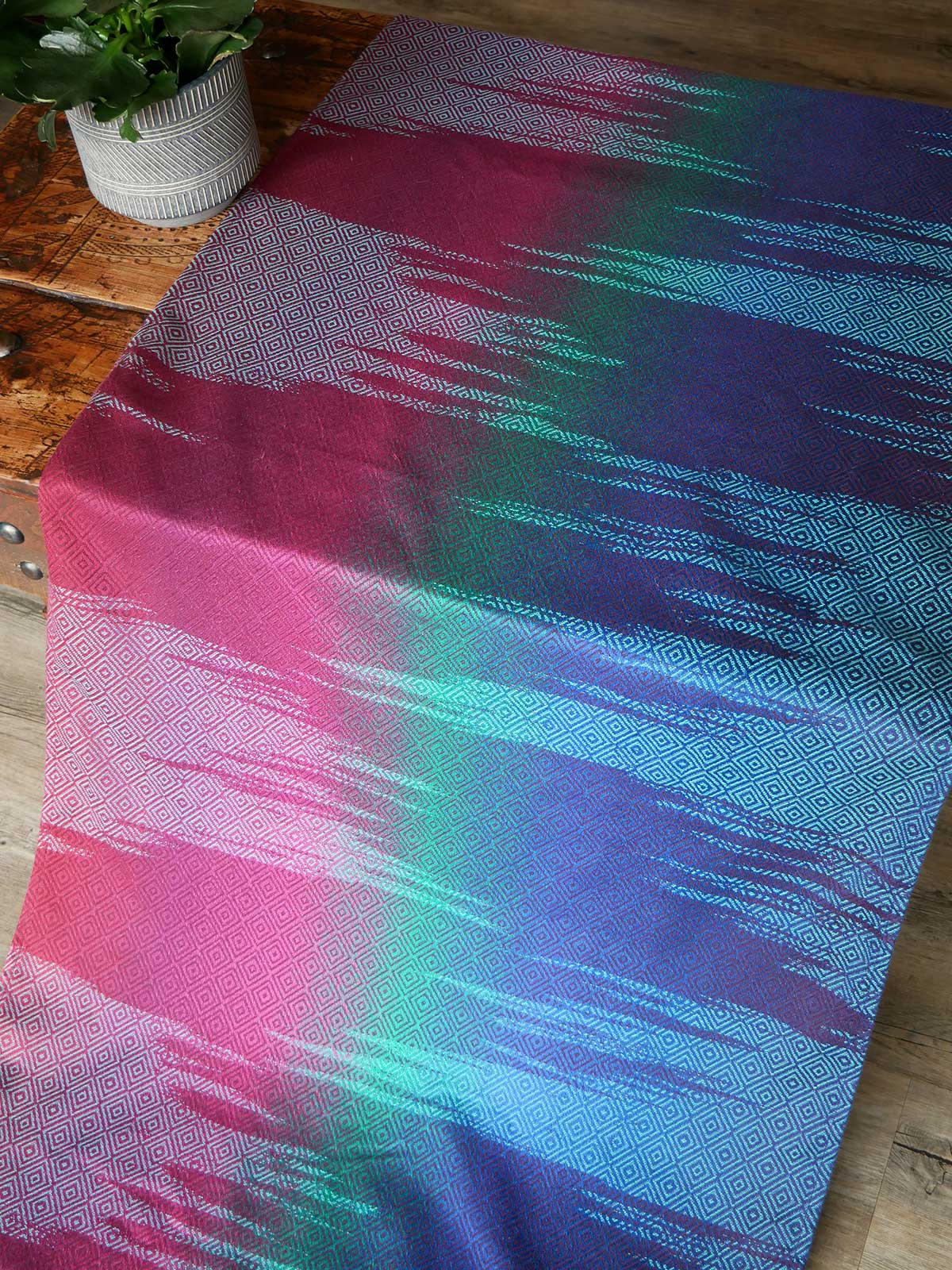 Fabric laid on a wooden table in jewel tones
