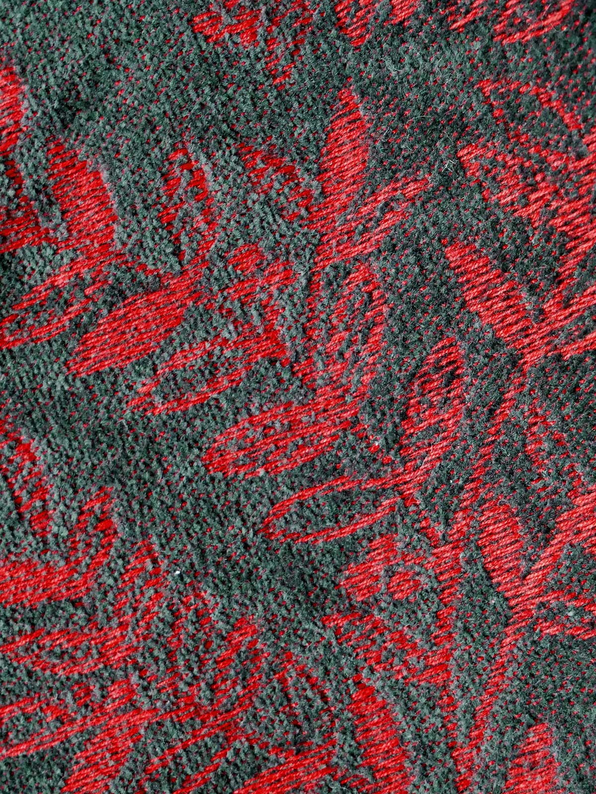 Textured fabric with red floral pattern on a dark background