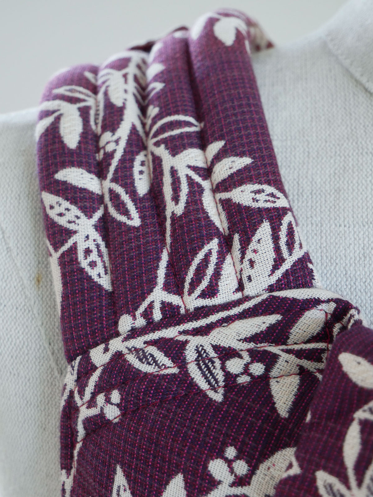 Purple fabric with white leaf pattern on a white background