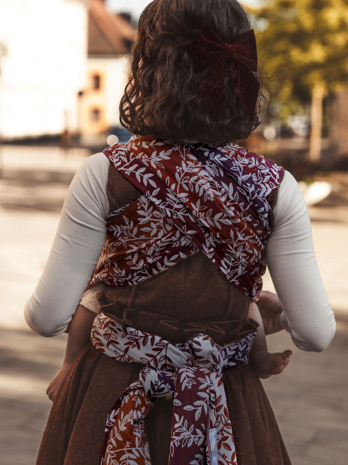 Person wearing a patterned baby carrier outdoors