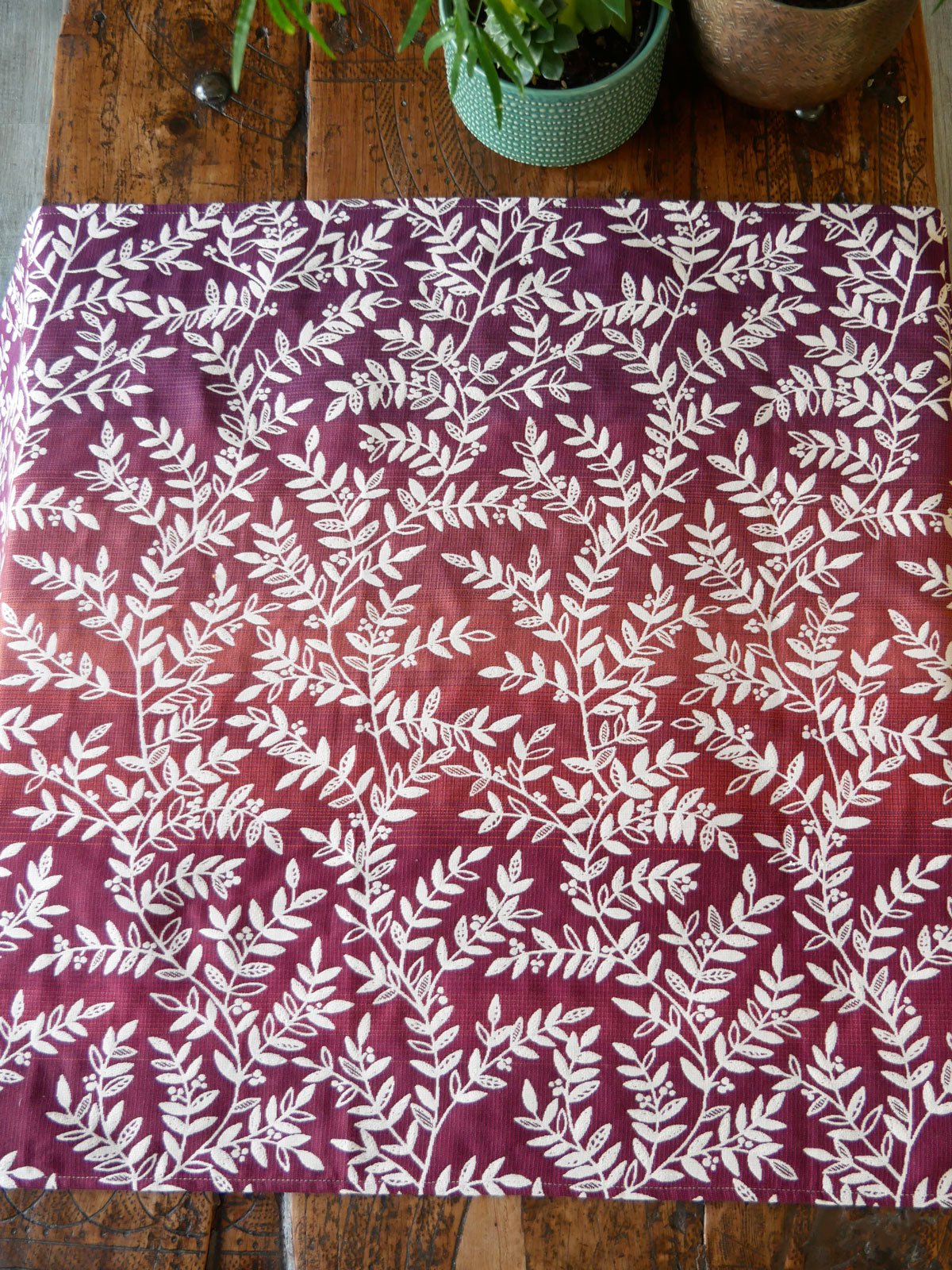 Woven wrap fabric with white leaf pattern on a burgandy purple background