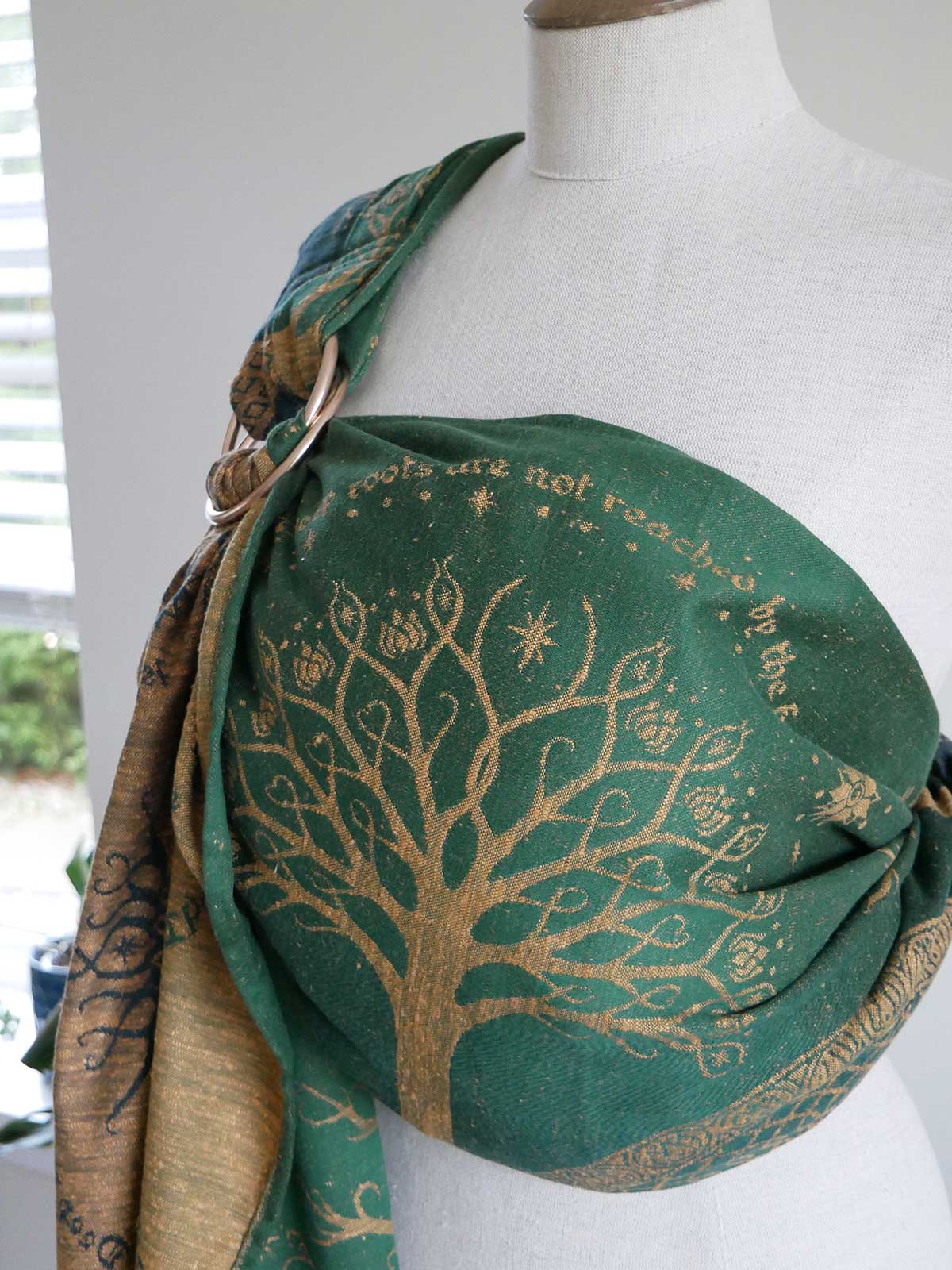 Green ring sling with gold tree design on a mannequin