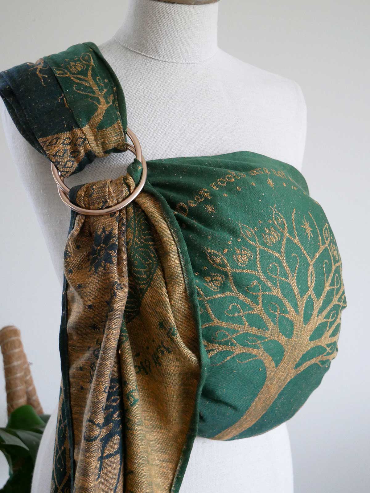 Mannequin wearing a green and gold patterned ring sling.