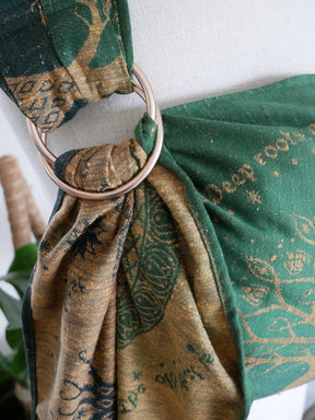 Close-up of a green and gold patterned ring sling.