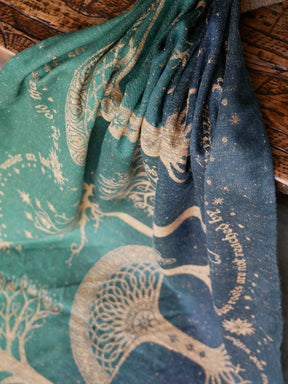 Patterned green and blue fabric with intricate designs on a wooden surface.