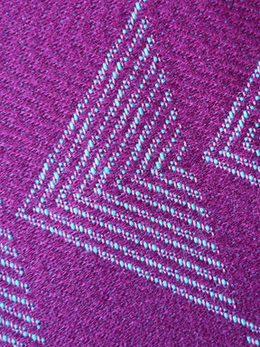 Close-up of a textured purple fabric with a geometric pattern