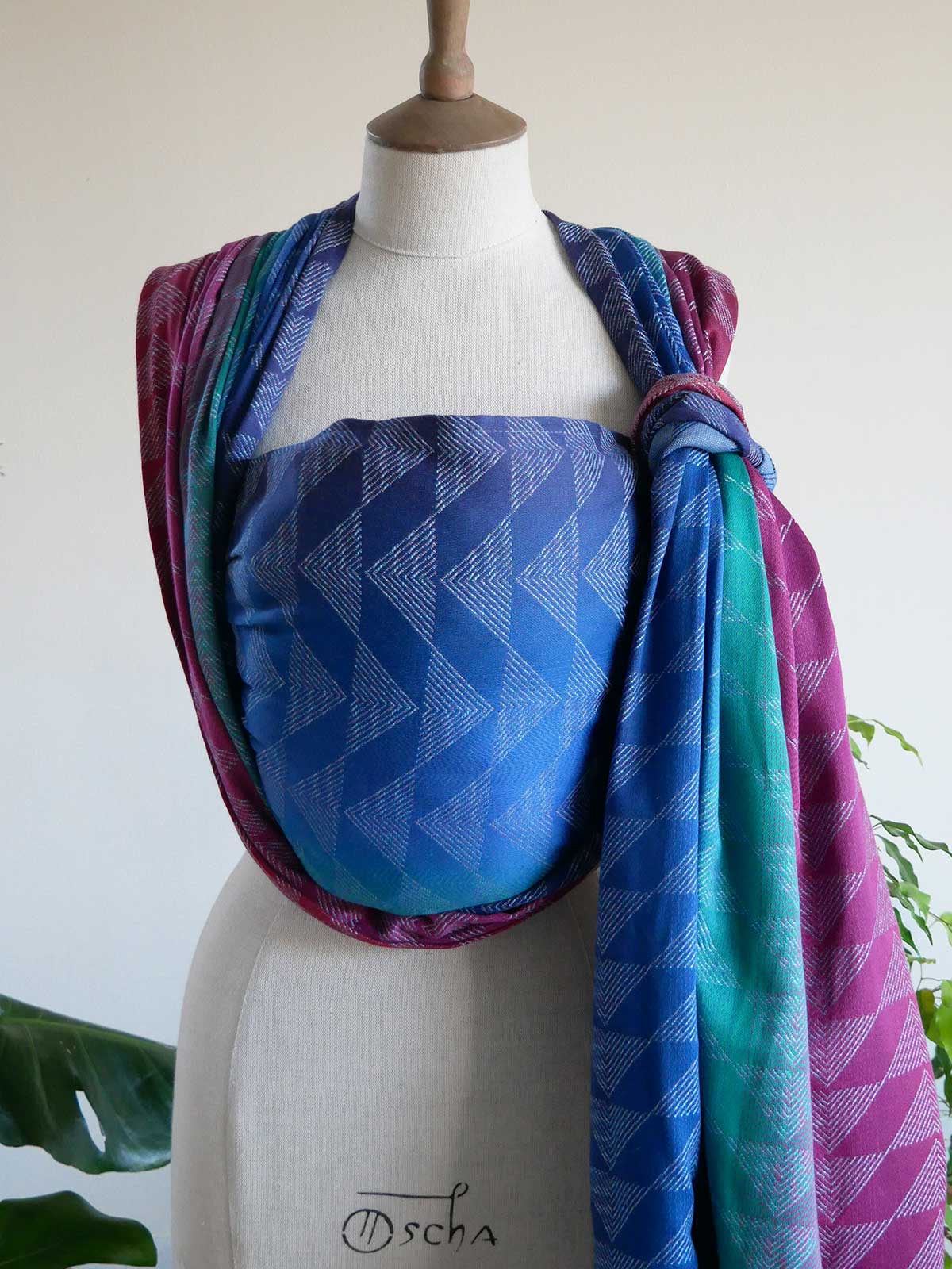 Colourful patterned fabric draped over a mannequin on a white background