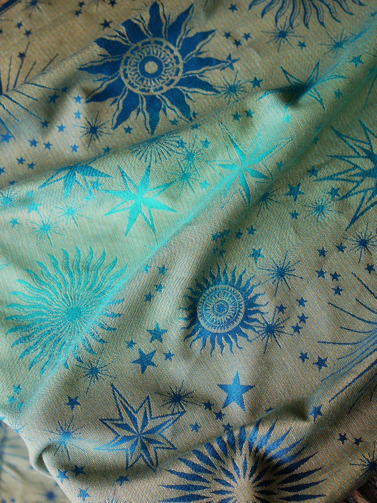 Reverse of teal fabric with starry pattern on a wooden surface