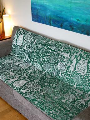 Wide view of green throw with folk art design.