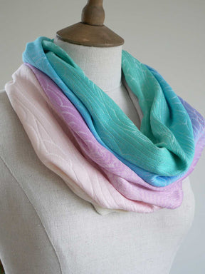 Pastel-colored cowl scarf on a mannequin against a neutral background