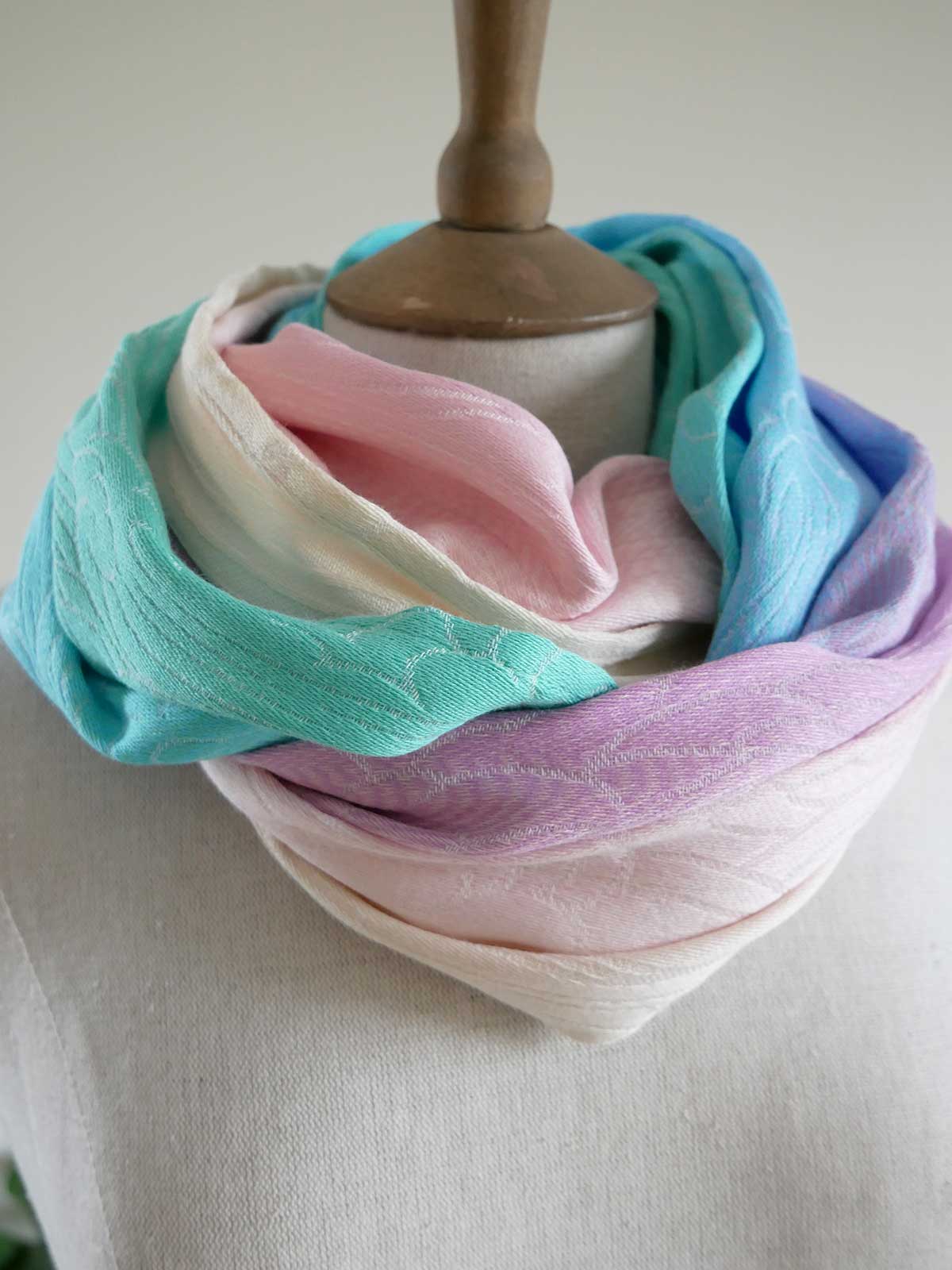 Pastel colored cowl scarf on a mannequin against a neutral background