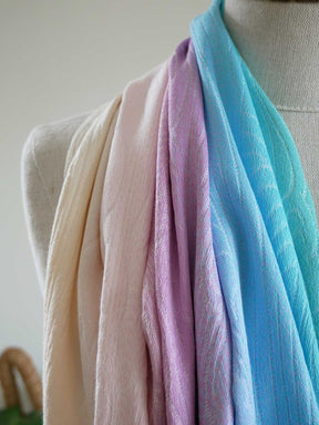 Pastel-colored scarf on a mannequin against a neutral background