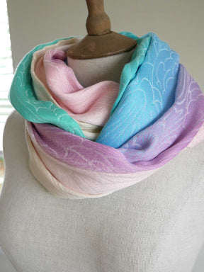 Pastel colored looped scarf on a mannequin with a neutral background