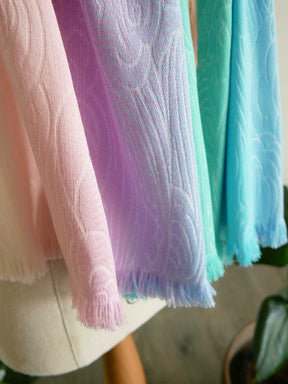 Pastel-colored scarves hanging on a rack