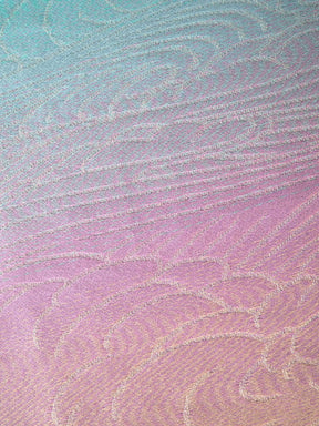 Textured fabric with a gradient pattern transitioning from blue to pink.